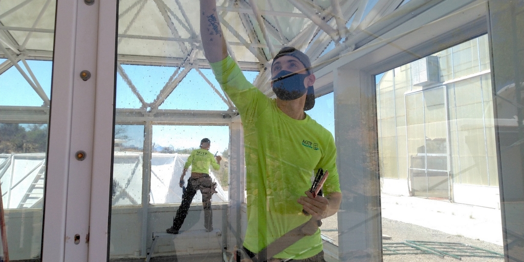 Greg and Tristen Spencer applying window tint to SAM at Biosphere 2