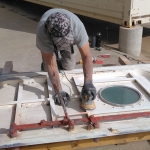 Nathan Schmit sands the third pressure door at SAM, Biosphere 2